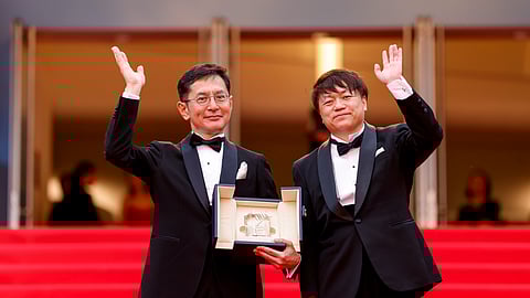 In frame: Goro Miyazaki (L) and Kenichi Yoda pose for photographers