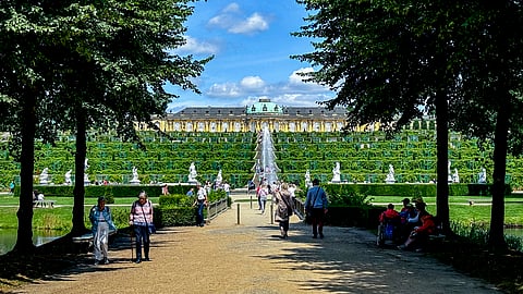 People walk in the park of the Sanssouci Palace in Potsdam, Germany