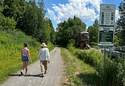Two people walk on the Lamoille Valley Rail Trail