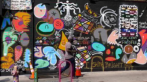 A man walks past a mural in the Harlem neighbourhood of New York (Aug. 15, 2024)