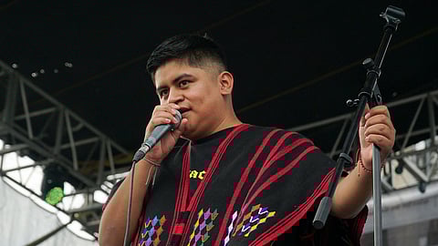 Mexican-Triqui artist Carlos CGH, wearing a black and red “gabán,” a garment native to the Triqui people in western Oaxaca, performs during a celebration of Indigenous peoples at the Zocalo in Mexico City