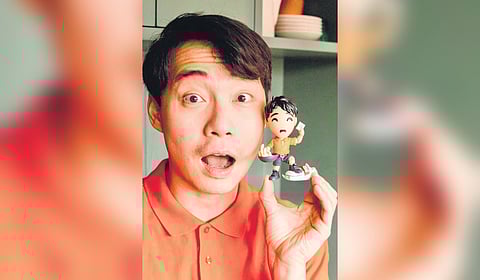 33-year-old comedian, Nigel Ng with a miniature of Uncle Roger.