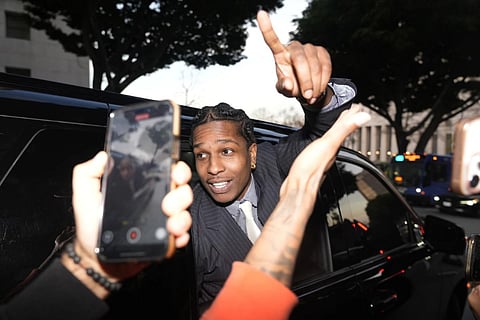 A$AP Rocky gestures out of the window of a vehicle while leaving court after he was found not guilty in his trial