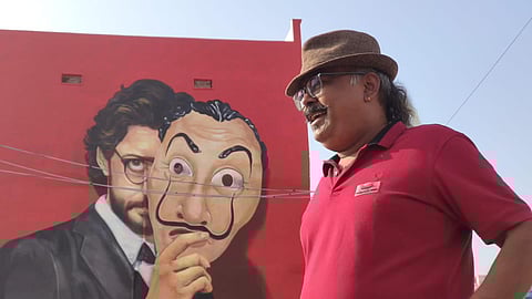 Ranjit Dahiya stands against one of his murals