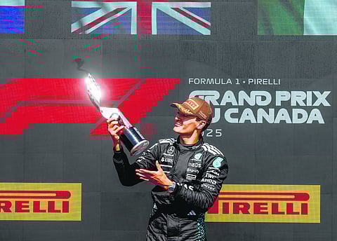 George Russell smiles at his prize at the Grand Prix
