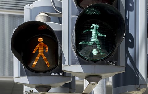 The green traffic light woman kicking a soccer ball before they cross the road during the Women's European Championship