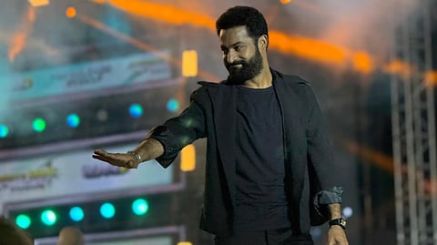 Jr NTR asks a fan to maintain silence as he speaks during a War 2 pre-release event