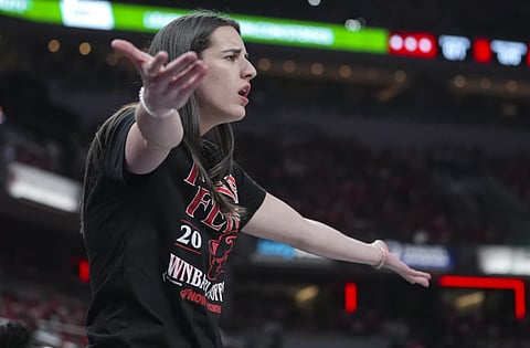 Indiana Fever guard Caitlin Clark (22) gestures on the bench in the first half of a WNBA basketball