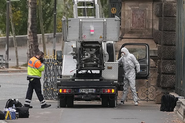 Police officers look for clues at the Louvre Museum robbery
