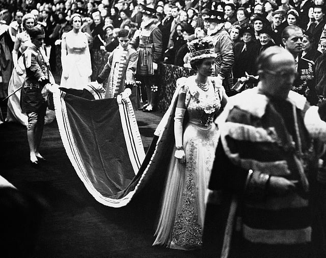 Queen Elizabeth II, wearing the imperial crown, walks through Royal gallery to the House of Lords chamber