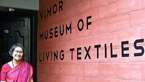 Pavithra Muddaya stands in front of the façade of Vimor Museum of Living Textiles