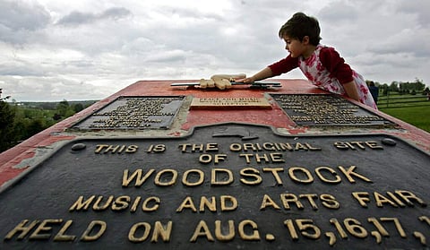 This May 15, 2008 file photo shows Emma Cenholt, 3, of Trumbull, Conn., playing on a memorial at the site of the Woodstock Music and Arts Fair in Bethel