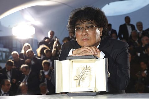Director Bong Joon-ho poses with the Palme d'Or award. (Photo by Vianney Le Caer/Invision/AP)