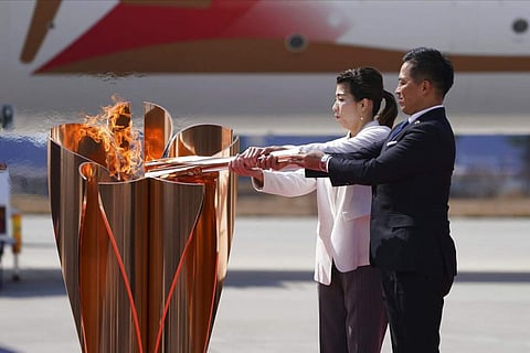 Tadahiro Nomura and Saori Yoshida light the torch during Olympic Flame Arrival Ceremony (AP Photo/Eugene Hoshiko)