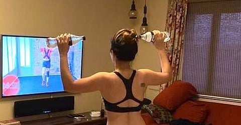 Paloma swaps out dumbbells for water bottles in a home workout session
