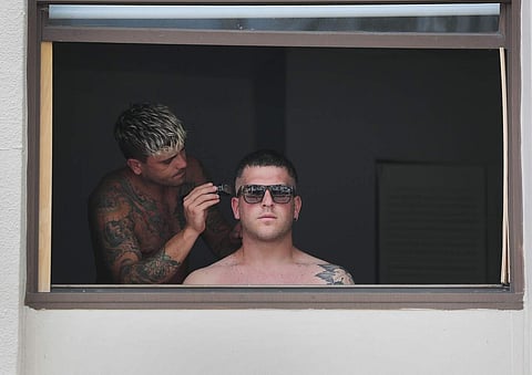 Nicole Spuntarilli cuts Stefano Pinto's hair in his apartment (AFP/GETTY IMAGES NORTH AMERICA/JOE RAEDLE)