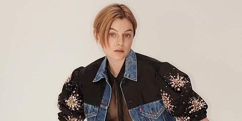 Emma Corrin sports a hand-embellished duchesse satin puff-sleeve trucker jacket and classic 501 blue jeans