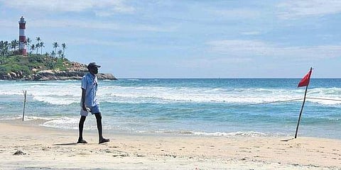A lifeguard takes a stroll on the deserted Kovalam beach in Thiruvananthapuram. The spread of Omicron variant has led to a decline in both domestic and international tourists.