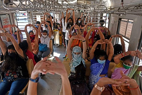 People performing yoga in a compartment of the local train