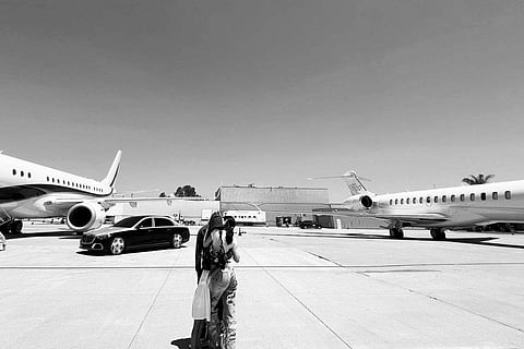 Kylie, Travis and Stormi embracing on a tarmac