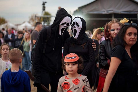 In frame: People wearing costumes talk at the West Side Hallo Fest, a Halloween festival in Bucharest, Romania