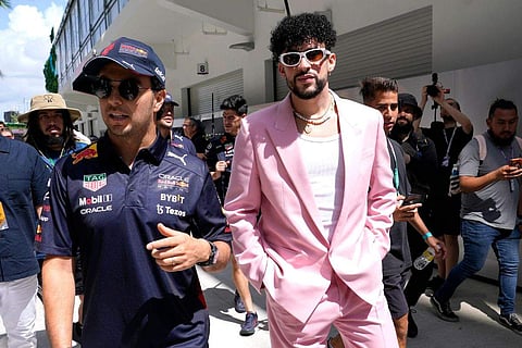 Red Bull driver Sergio Perez, of Mexico, left, walks with Puerto Rican reggaeton musician Bad Bunny before a Formula One Miami Grand Prix auto race
