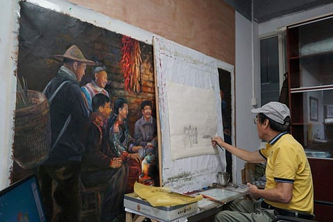 Zeng Fanzhi, a retired architect turned artist, paints at his studio in Shenzhen in southern China's Guangdong province