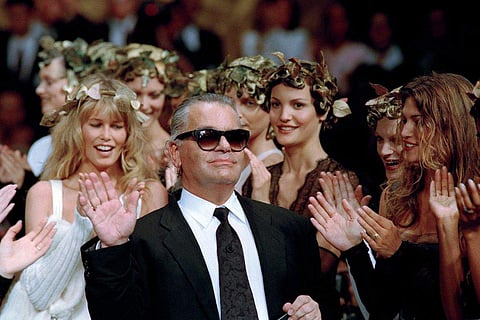 German fashion designer Karl Lagerfeld acknowledges the applause of his models at the end of a show he designed for the French fashion house Chanel