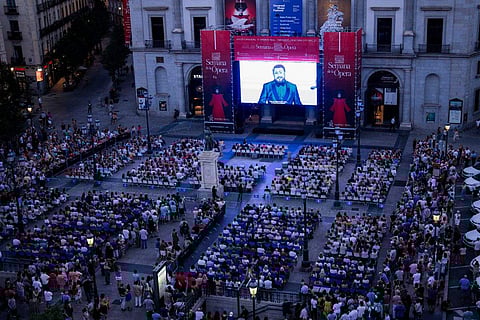 Opera fans and passers-by watch Giacomo Puccini's Turandot opera on a giant screen in a square