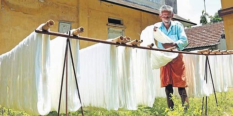 Ratnan K P (Kuttan), who has been working in the handloom sector for nearly five decades, hanging bleached yarn for drying in the sun (Photo | T P Sooraj)