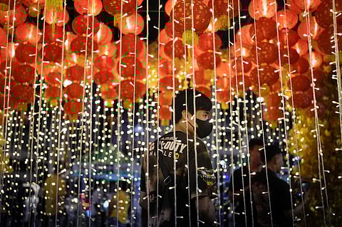 A man stands under lanterns during an event for the 430th anniversary of Manila's Chinatown