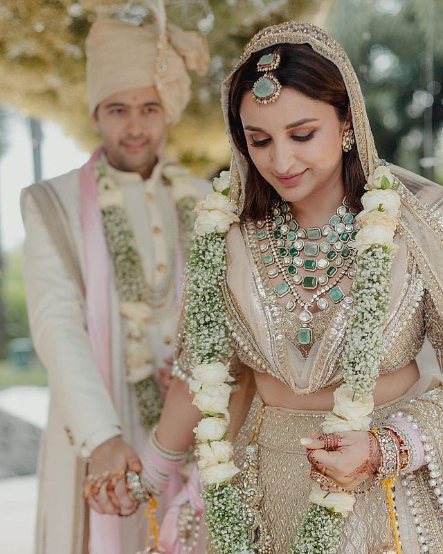 Parineeti wore multi-tiered necklace featuring Uncuts, Zambian and Russian emeralds in an antique finish, paired with earrings, a maang tikka, haathphool and bangles