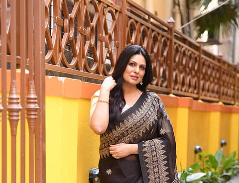 A black khadi linen sari with ghicha jamdani work paired with a kora tussar and silk brocade blouse by Utsab