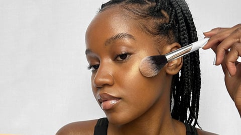 A lady applying highlighter