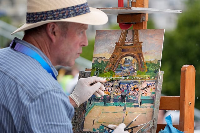 Peter Spens paints the scene at Eiffel Tower Stadium during a beach volleyball match (July 27)