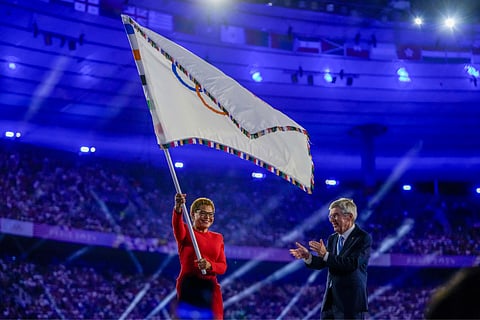 Los Angeles Mayor Karen Bass waves the Olympic flag as IOC President Thomas Bach applauds during the 2024 Summer Olympics closing ceremony at the Stade de France (Aug. 11) in Saint-Denis, France
