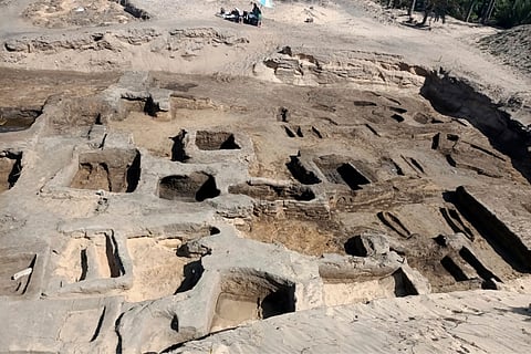 In this image provided by Egypt's Supreme Council of Antiquities, archeologists observe the site where they discovered 63 mud-brick tombs at the Tell al-Deir necropolis, in the Nile Delta town of Damietta, north of Cairo, Egypt