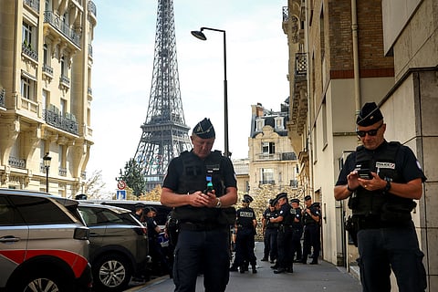 Police officers gather in a street near the Eiffel Tower on the eve of the Paralympic Games opening ceremony in Paris (Aug. 27, 2024)