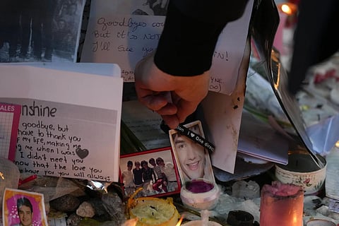 Geoff Payne, the father of Liam Payne, touches a gel bracelet hanging on a picture of his son while visiting a memorial outside the Casa Sur Hotel where the British pop singer fell to his death from a hotel balcony