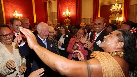 Britain's King Charles III, second from left, and Queen Camilla, third from left, smile as former Samoan rugby player Freddie Tuilagi dances during a reception to celebrate the Commonwealth Diaspora of the United Kingdom, ahead of the Commonwealth Heads of Government Meeting in Samoa, at St. James's Palace