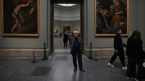 Novelist John Banville poses between Tiziano’s ‘Sisyphus’ on the left and Tityus on the right at the Prado Museum in Madrid