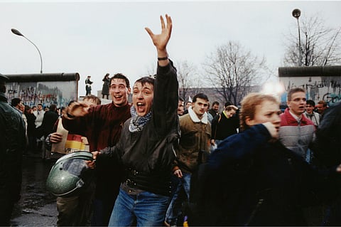 FILE - Young East Berliners shout for joy as they run into West Berlin through an opening in the Berlin Wall near the Brandenburg Gate, on Dec. 23, 1989