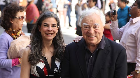 Arthur Frommer (R) and his daughter, Pauline Frommer (L), pose among tourists in the Wall Street area in New York, May 20, 2012