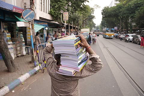 Books being transported on shoulders from one stall to the other
