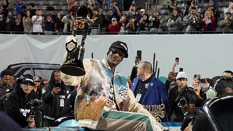 Rapper Snoop Dogg, center, arrives with the trophy after Miami (Ohio) defeated Colorado State in the Arizona Bowl NCAA college football game
