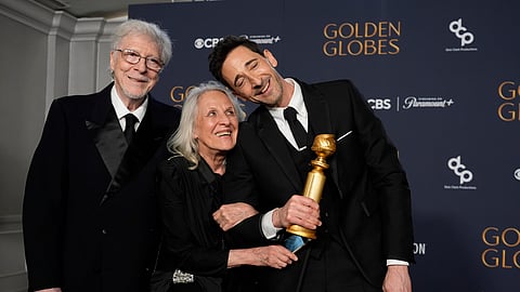 Elliot Brody, from left, Sylvia Plachy, and Adrien Brody, winner of the award for best performance by a male actor in a motion picture drama for The Brutalist, pose in the press room during the 82nd Golden Globes 