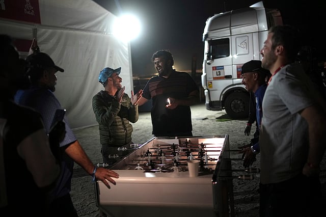 Workers at the bivouac play table soccer after the tenth stage of the Dakar Rally between Haradh and Shubaytah, Saudi Arabia, Wednesday, Jan. 15, 2025.
