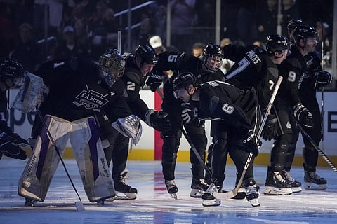 Team Black player singer Justin Bieber high fives teammates during the 'Skate for LA Strong' celebrity hockey game