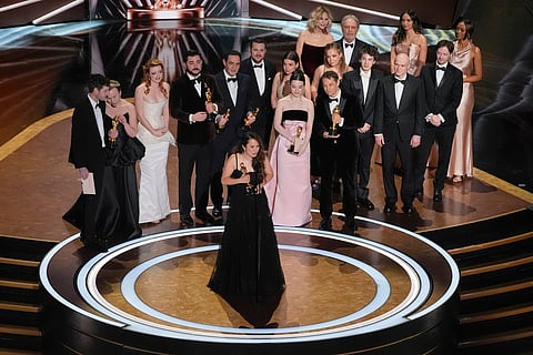 Samantha Quan, front centre, accepts the award for best picture for 'Anora' during the Oscars on Sunday, March 2, 2025, at the Dolby Theatre in Los Angeles. Alex Coco (from rear left), Darya Ekamasova, Lindsey Normington, Vache Tovmasyan, Karren Karagulian, Vincent Radwinsky, Luna Sofía Miranda, Mikey Madison, Sean Baker, Mark Eydelshteyn, Yura Borisov, Meg Ryan, and Billy Crystal look on from back
