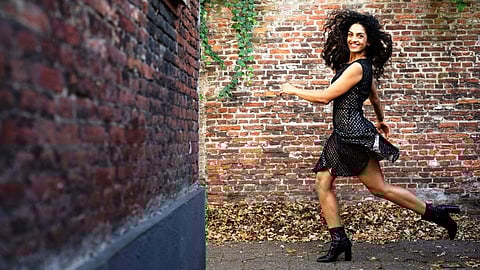 Dancer, actress and now stand-up comedienne Rukmini Vijayakumar poses mid-step in front of a wall